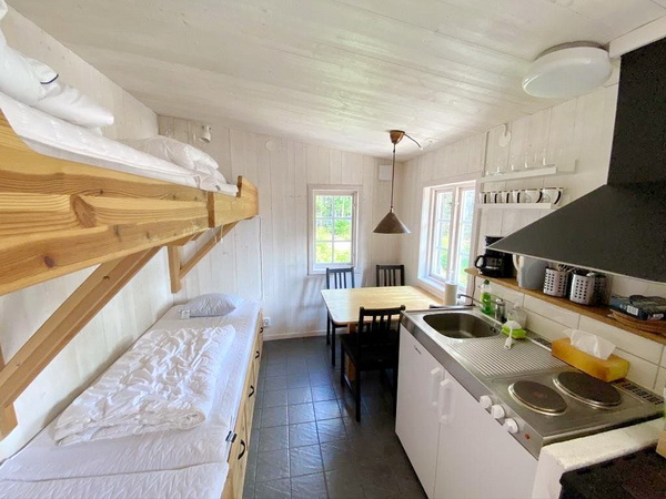 kombinierter Wohn- und Schlafraum mit 4 Betten, Esstisch und Pantryküche