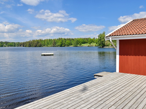 Bootshaus mit hauseigenem Ruderboot und Terrasse am See