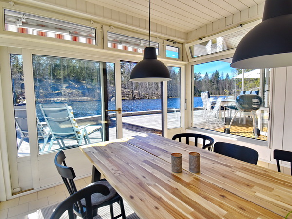 Wintergarten mit großer Schiebetür zur Terrasse am See